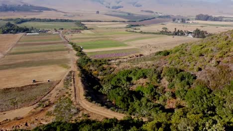 Drone-Disparó-Sobre-La-Colina-Con-Tierras-De-Cultivo-Y-Colinas-En-El-Fondo
