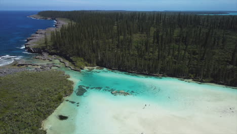 The-amazing-crystal-clear-waters-of-the-natural-pool-at-Oro-Bay-in-the-Isle-of-Pines---aerial-parallax-reveal