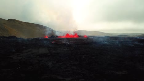 Aerial-landscape-view-of-magma-and-lava-erupting-in-Meradalir-valley,-from-Fagradalsfjall-volcano,-with-smoke-coming-out
