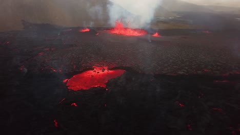 Aerial-view-of-lava-erupting-in-Meradalir-valley,-from-Fagradalsfjall-volcano,-with-smoke-coming-out