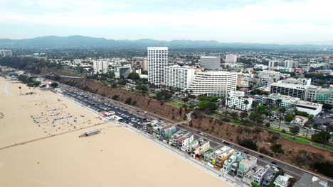 Aerial-view-flying-across-Santa-Monica-boulevard,-California-sandy-golden-beach-resort-coast