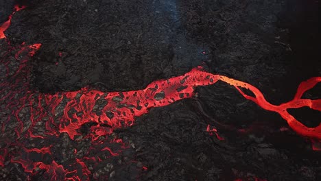 Aerial-view-above-a-river-of-lava-flowing-across-Meradalir-valley,-Iceland,-erupting-out-of-Fagradalsfjall-volcano