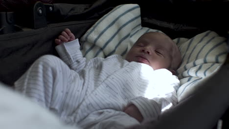 Calm-asian-newborn-sleeping-in-infant-car-bed