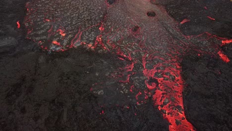 Aerial-view-of-a-river-of-lava-flowing-across-Meradalir-valley,-Iceland,-erupting-out-of-Fagradalsfjall-volcano