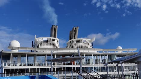 Huge-Cruise-ship-Chimney-or-smoke-funnel-with-a-smoke-billowing-out-in-the-skies-video-background-|-one-Smokestack-out-of-two-on-cruise-ship-with-smoke-billowing-out-into-the-sky
