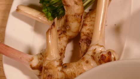 Galangal-and-Coriander-Root-on-White-Plate,-Close-Up-1
