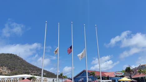 Bandera-De-La-Isla-Virgen-De-Estados-Unidos-Y-Media-Asta-De-Estados-Unidos-Ondeando-En-Honor-A-Las-Victimas-De-La-Tragedia-|-Banderas-De-La-Isla-Virgen-De-St-Thomas-Y-Estados-Unidos-Ondeando-En-El-Puerto-De-Charlotte-Amalie,-Islas-Vírgenes-De-Los-Estados-Unidos