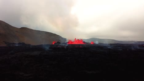 Vista-Aérea-Ascendente-De-Magma-Y-Lava-En-Erupción-En-El-Valle-De-Meradalir,-Del-Volcán-Fagradalsfjall,-Con-Humo-Saliendo
