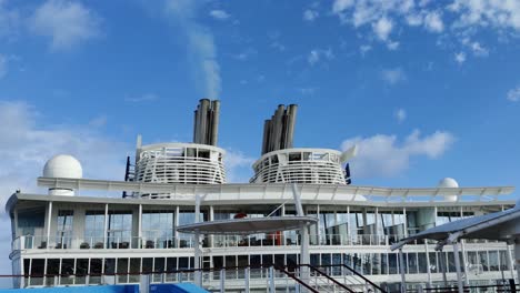 Huge-Cruise-ship-Chimney-or-smoke-funnel-with-a-smoke-billowing-out-in-the-skies-video-background-|-one-Smokestack-out-of-two-on-cruise-ship-with-smoke-billowing-out-into-the-sky-2
