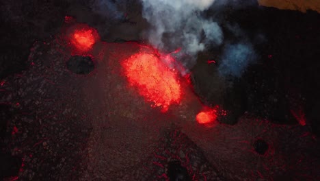 Aerial-view-of-magma-and-lava-erupting-in-Meradalir-valley,-from-Fagradalsfjall-volcano,-with-smoke-coming-out