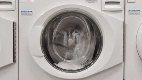 Close-up-video-of-spinning-drum-washing-machine-|-Washing-clothing-in-domestic-washing-machine-in-home