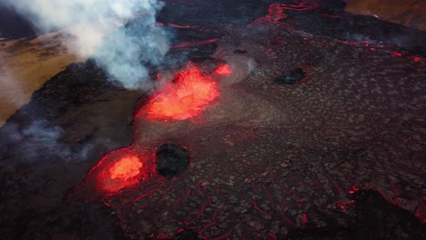 Aerial-view-over-magma-and-lava-erupting-in-Meradalir-valley,-from-Fagradalsfjall-volcano,-with-smoke-coming-out