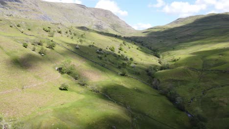 Sunny-Drone-View-Of-Kirkstone-Pass-Area-Valley-Floor-With-Cloud-Shadows-On-Fields-Looking-Up-To-Red-Screes-Fell-In-The-Summer