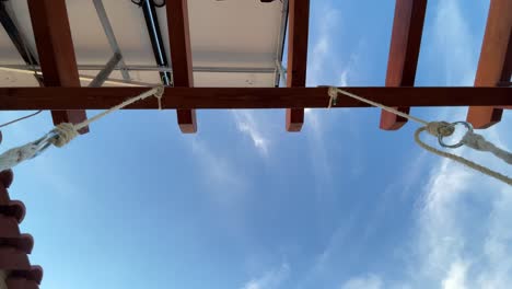 View-of-sky-and-wooden-canopy-of-outdoor-garden-swing