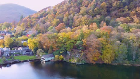 Drone-View-Of-Colourful-Autumn-Tree-Scene-With-Boat-House-In-Glenridding-On-Ullswater-,-Lake-District-National-Park