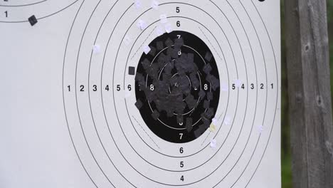 Bullets-punching-through-shooting-target-close-up---Static-clip-seeing-bullet-holes-penetrating-black-and-white-shooting-target