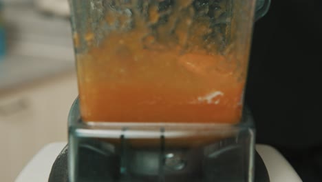 Closeup-of-blender-blades-as-it-starts-to-mix-white-and-orange-ingredients