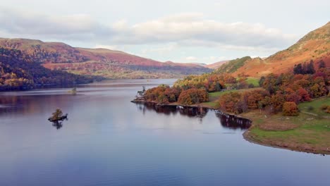 Scenic-Drone-View-Of-Colourful-Autumn-Lake-District-Lake-Scene-With-Forrest-And-Island