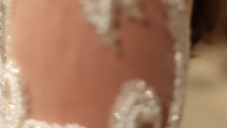 Close-up-circling-shot-of-torso-of-bride-with-beautifully-decorated-dress