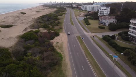 Car-driving-along-coastal-road-and-beach-of-Punta-del-Este-in-Uruguay