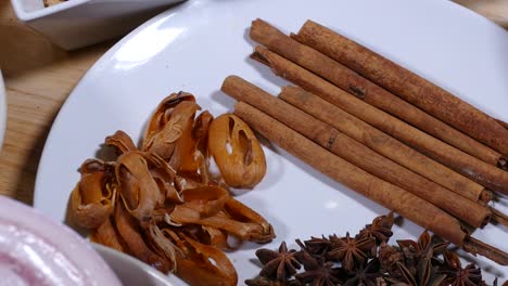 Cinnamon,-Star-Anise-and-Herb-on-White-Plate,-Close-Up