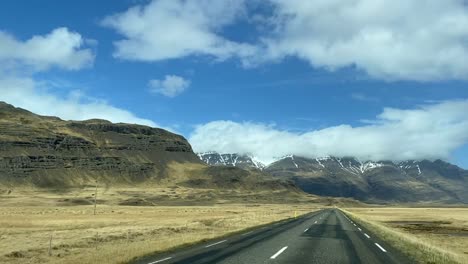 Conduciendo-Por-Una-Carretera-Rural-En-Las-Tierras-Altas-De-Islandia,-El-Punto-De-Vista-Del-Conductor-Del-Paisaje-Y-Las-Montañas-Volcánicas