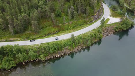Cars-passing-by-a-lake-in-Norway