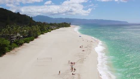 People-enjoying-vacation-on-Sunset-Beach,-Pupukea,-Hawaii,-drone-view
