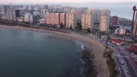 Drone-flight-along-coast-and-sandy-beach-of-Punta-del-Este-City-during-golden-sunset-in-Uruguay
