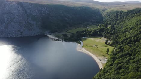 Beautiful-serene-landscape-Lough-Tay-Lake,-Guinness-Lake-in-the-Wicklow-Mountains,-with-the-green-forest-on-a-sunny-day