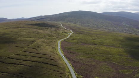 Aerial-view-of-cars-driving-on-a-long,-winding-mountain-road-in-the-Wicklow-Mountains-on-a-sunny-day-6