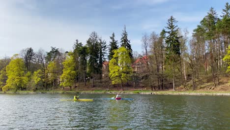 Two-kayakers-kayaking-on-dam-or-pond-in-Liberec,-Czech-Republic,-wide-angle-view,-sunny-day