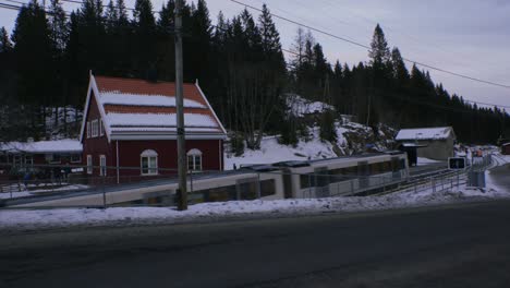 Train-departing-from-Voksenkollen,-next-to-elementary-school,-Oslo-vinterpark,-winter-park