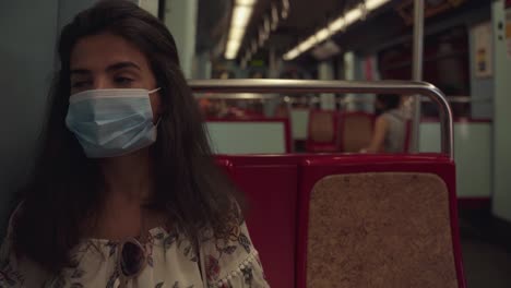 Young-and-tired-tourist-wearing-face-mask-in-public-transport,-traveling-in-Portugal
