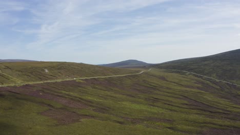 Aerial-view-of-cars-driving-on-a-long,-winding-mountain-road-in-the-Wicklow-Mountains-on-a-sunny-day-2