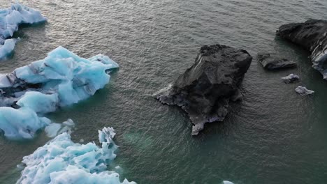Paso-Elevado-De-Icebergs-En-Jokulsarlon-Con-Pan-Hacia-Arriba-Hacia-El-Casquete-De-Hielo-Vatnajokull