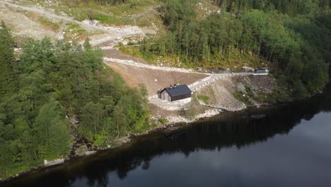 Miniature-hydroelectric-powerplant-by-Bolstadfjord-in-Vaksdal-Norway---Aerial-showing-powerplant-in-beautiful-scenery-by-the-fjord