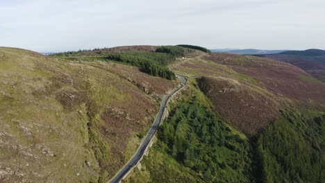 Aerial-view-of-cars-driving-on-a-long,-winding-mountain-road-in-the-Wicklow-Mountains-on-a-sunny-day-1