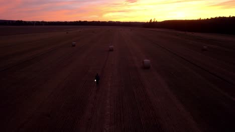 Aerial-drone-view-of-a-man-walking-in-the-middle-of-the-field-after-harvest