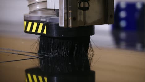 A-tight-shot-of-a-tabled-CNC-router-cutting-black-signage-in-slow-motion