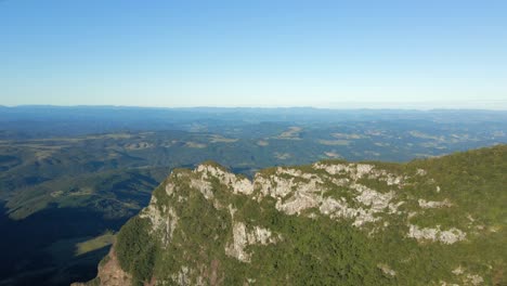 Aerial-flying-over-mountain-ridge-revealing-green-valley-in-Serra-do-Corvo,-Brazil
