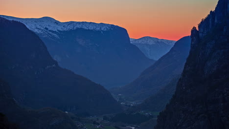 Timelapse-shot-of-darkness-falling-over-the-valley-surrounded-by-high-mountains-during-evening-time