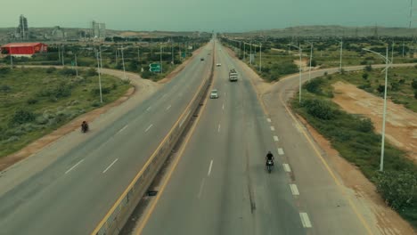 Antenne,-Die-über-Die-Karachi-Autobahn-Zurückfliegt,-Während-Der-Verkehr-Vorbeigeht
