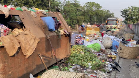 Road-sideway-covered-in-piles-of-garbage-in-Dhaka-city,-handheld-view