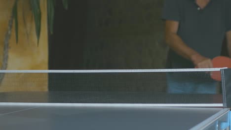 Slow-motion-of-a-boy-hitting-a-backhand-ball-during-a-game-of-ping-pong-in-a-corporate-team-building-moment