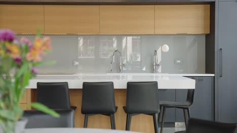 Modern-bright-kitchen-with-2-sinks-and-black-barstools-on-a-large-kitchen-island