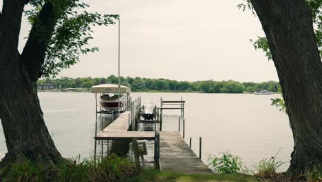 A-dock-with-boats-on-a-lake-with-a-large-boat-moving-in-the-background