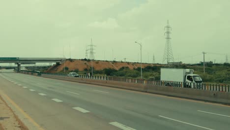 Aerial-Rising-Shot-Beside-Karachi-Motorway-With-Pylons-In-Background