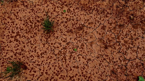 Time-lapse-shot-of-raindrops-falling-on-brown-sandy-ground-during-stormy-day---close-up-top-view