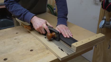 Craftsman-Using-A-Wood-Plane-On-A-Piece-Of-Ebony-Wood-To-Create-New-Items